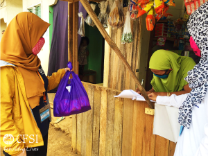 CFSI staff (right) hands dignity kit to a household in Marawi. The dignity kits are provided by the Global Network of Women Peacebuilders (GNWP) from New York, USA. 