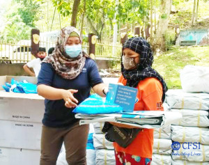 CFSI staff (left) hands core relief items to an internally displaced person (right) as additional protection amid the COVID-19 situation.